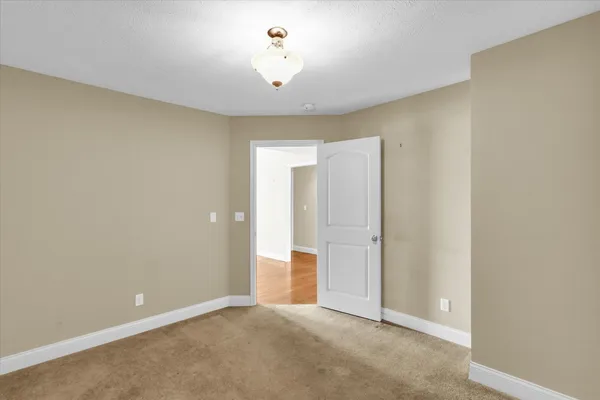 an empty room with chandelier fan and closet