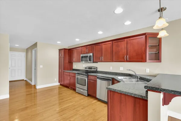 a kitchen with stainless steel appliances granite countertop a sink stove and refrigerator