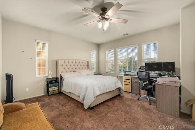 a spacious bedroom with a bed and a chandelier