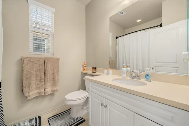 a bathroom with a sink a toilet and a large mirror