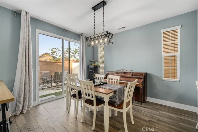 a view of a dining room with furniture large windows and wooden floor