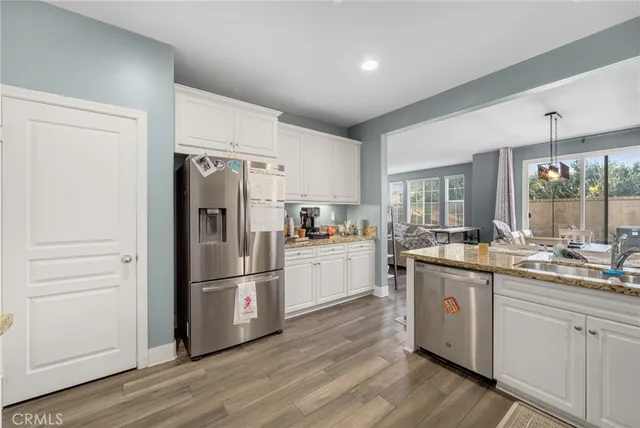 a kitchen with a refrigerator a sink and dishwasher with white walls