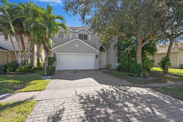 a front view of a house with a yard and trees