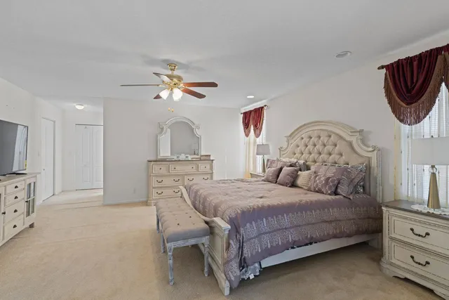 a bedroom with a bed a chandelier with a dresser and a chandelier