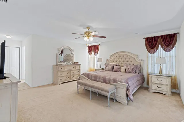 a bedroom with a bed a chandelier and dresser