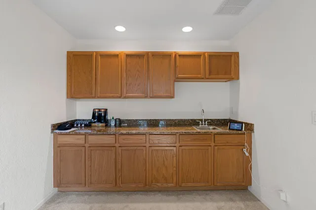 a kitchen with stainless steel appliances granite countertop a stove a sink and a microwave
