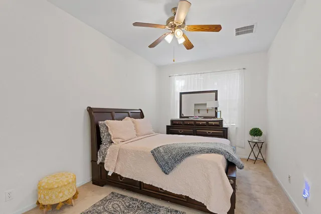 a bedroom with a bed and ceiling fan