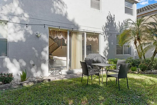 a view of a house with backyard and sitting area