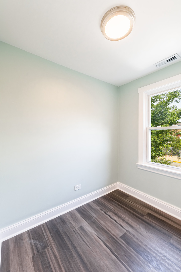 2027 West 18th Place, Unit 2 Chicago, IL 60608 - Photo 11 of 21 an empty room with wooden floor and windows