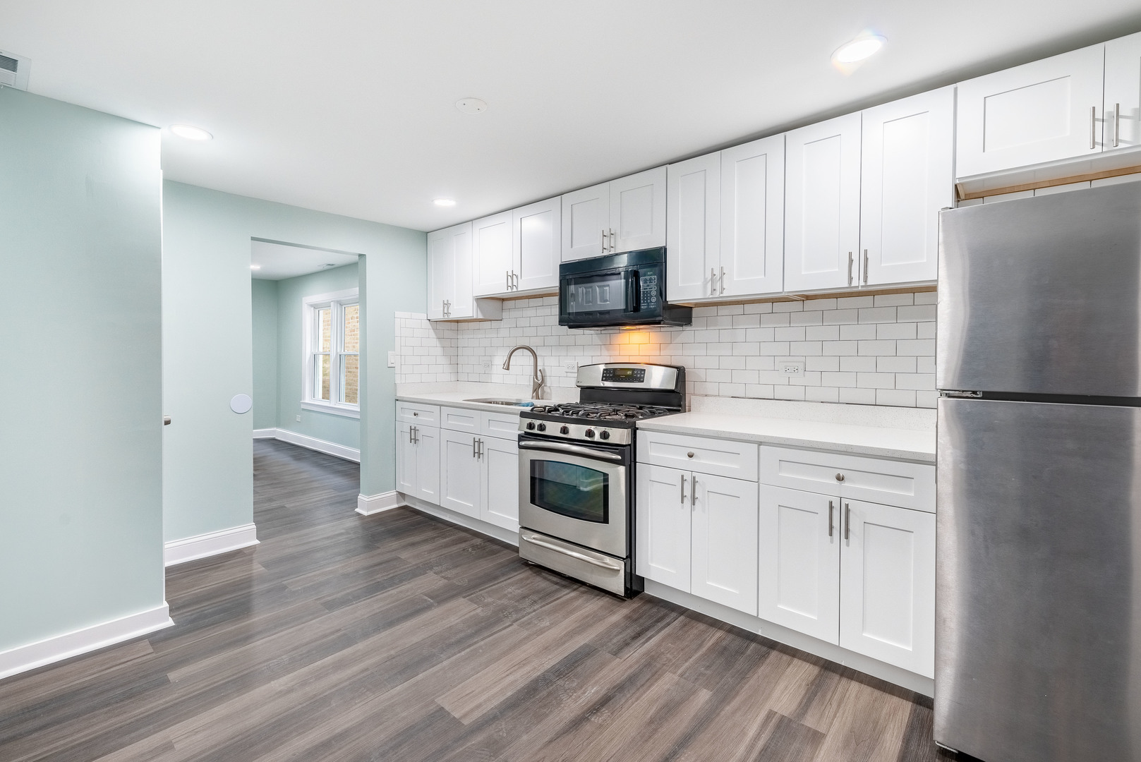 2027 West 18th Place, Unit 2 Chicago, IL 60608 - Photo 3 of 21 a kitchen with white cabinets and stainless steel appliances