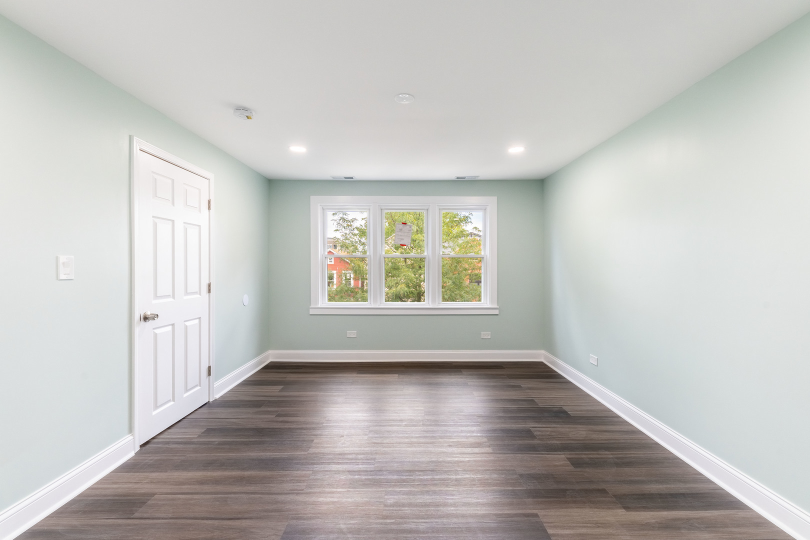 2027 West 18th Place, Unit 2 Chicago, IL 60608 - Photo 5 of 21 a view of an empty room with wooden floor and a window