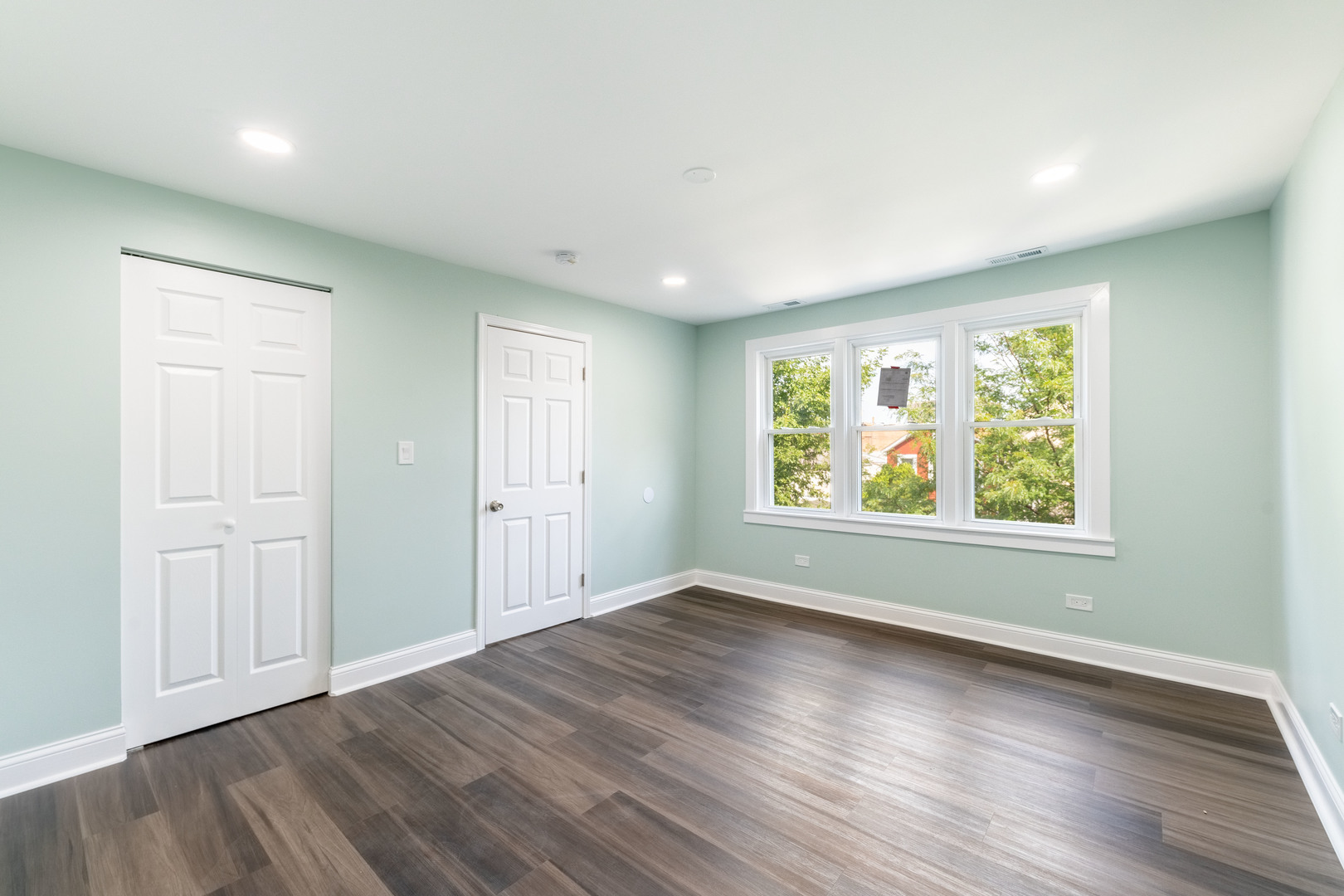 2027 West 18th Place, Unit 2 Chicago, IL 60608 - Photo 8 of 21 an empty room with wooden floor and windows
