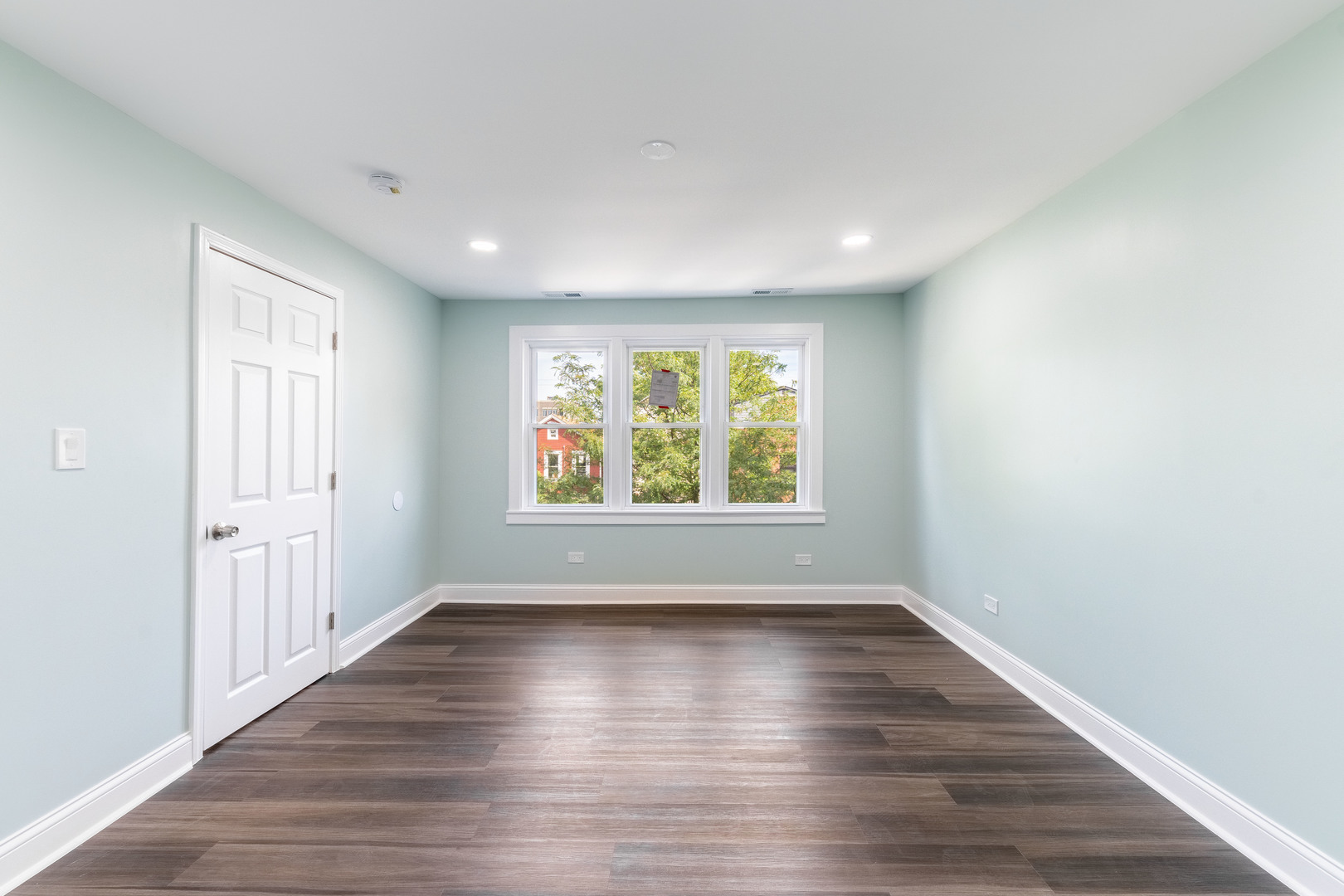 2027 West 18th Place, Unit 2 Chicago, IL 60608 - Photo 9 of 21 a view of an empty room with wooden floor and a window