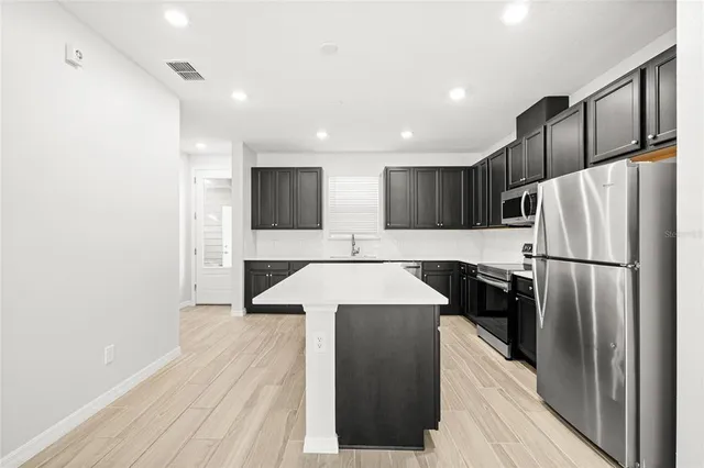 a kitchen with stainless steel appliances a refrigerator and a stove top oven