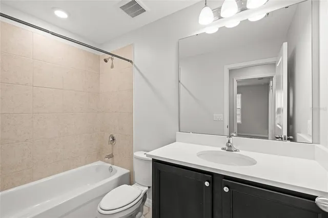 a bathroom with a sink a toilet a mirror a bathtub and shower