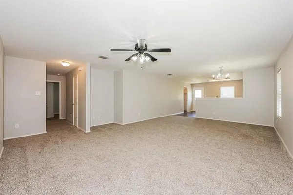 an empty room with chandelier fan