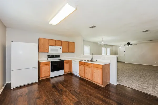 a kitchen with stainless steel appliances granite countertop a sink cabinets and wooden floor