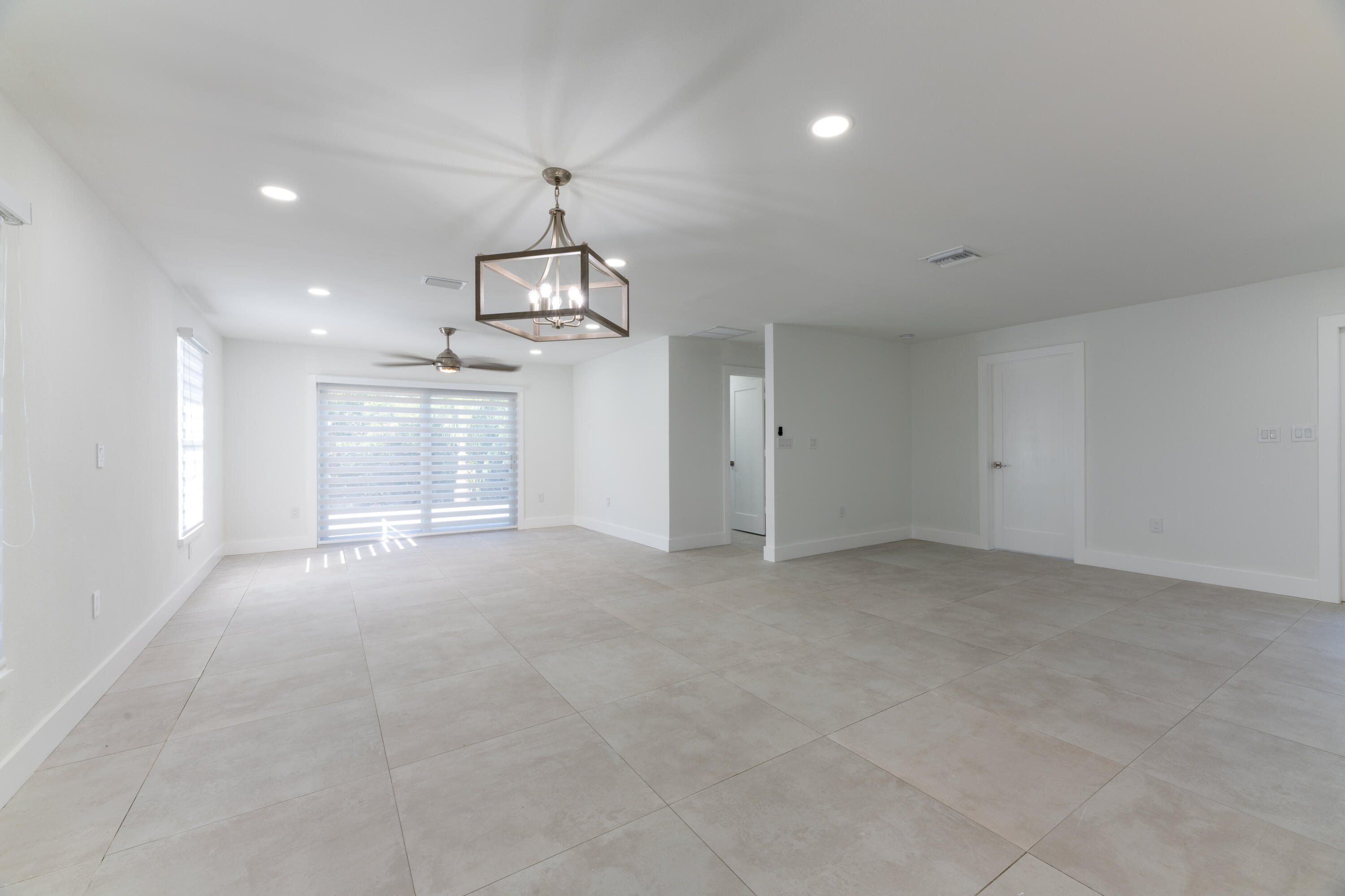13757 Cocoanut Avenue Juno Beach, FL 33408 - Photo 15 of 31 a view of empty room with chandelier fan and windows