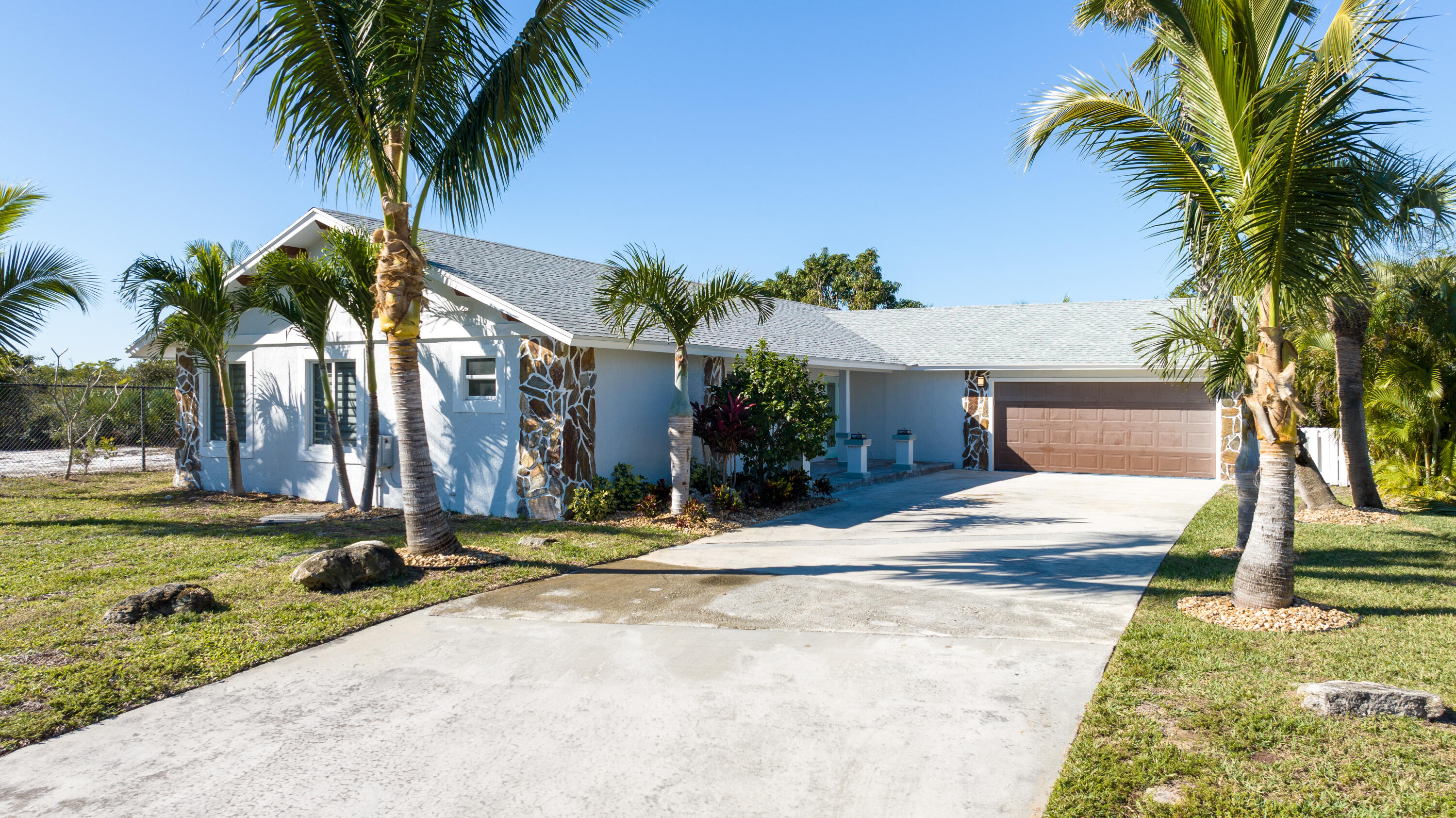 13757 Cocoanut Avenue Juno Beach, FL 33408 - Photo 31 of 31 a view of a house with a yard and palm trees