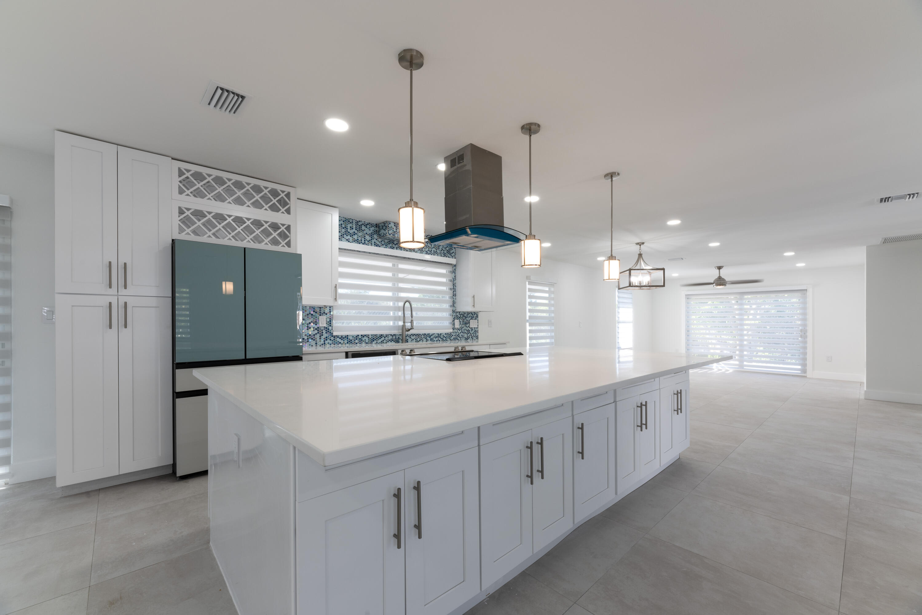 13757 Cocoanut Avenue Juno Beach, FL 33408 - Photo 4 of 31 a large white kitchen with a large island oven a sink stainless steel appliances and cabinets