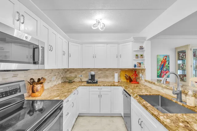 a kitchen with granite countertop a sink stove and cabinets