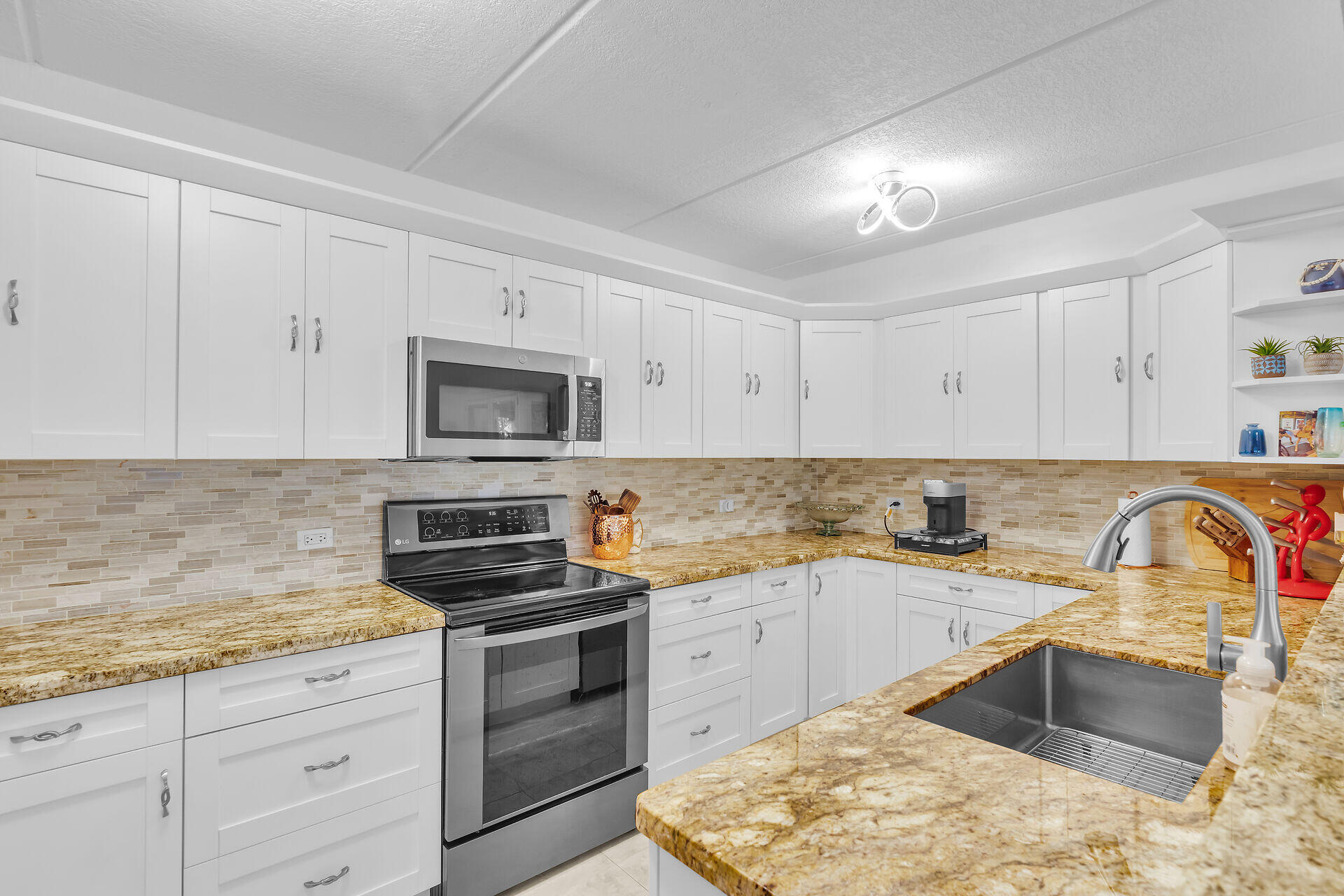 591 Sombrero Beach Road, Unit 8B Marathon, FL 33050 - Photo 15 of 43 a kitchen with granite countertop a sink stove and cabinets