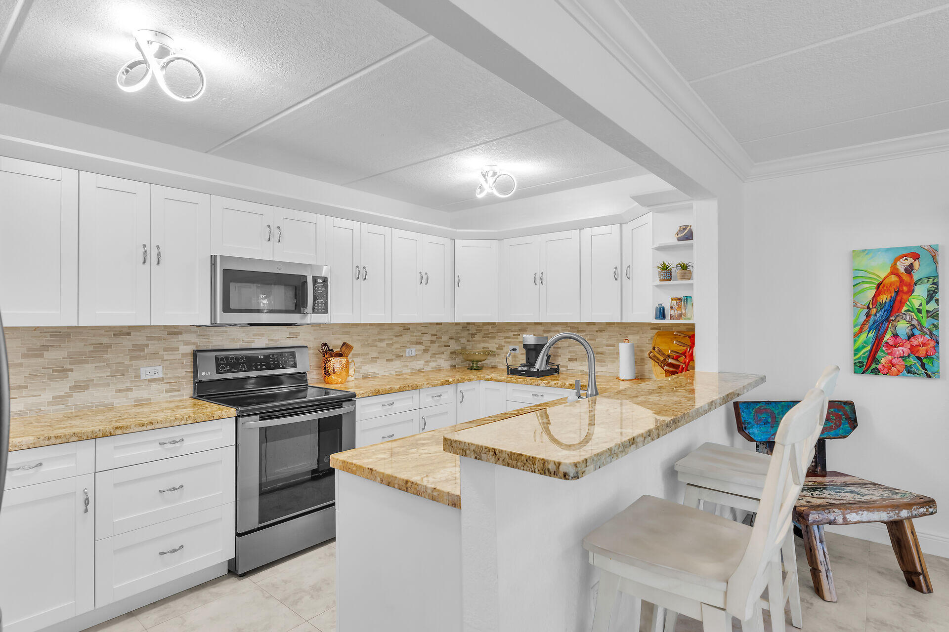 591 Sombrero Beach Road, Unit 8B Marathon, FL 33050 - Photo 32 of 43 a kitchen with granite countertop a sink stainless steel appliances and white cabinets
