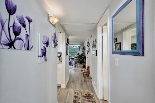 a kitchen with stainless steel appliances white cabinets and wooden floor