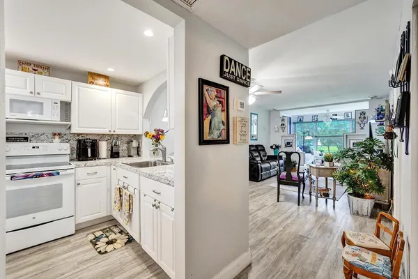 a kitchen with refrigerator a stove a sink and cabinets