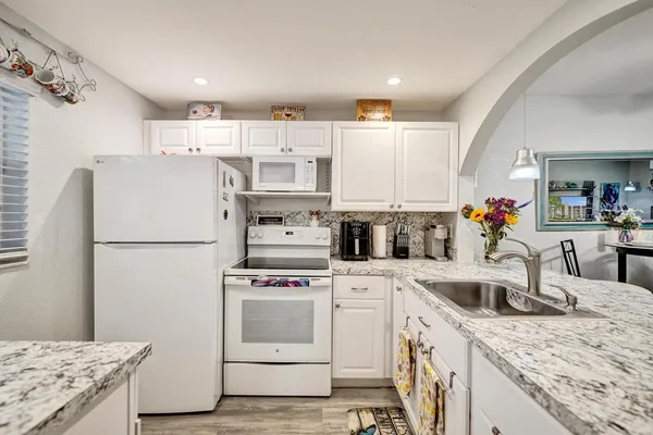 a kitchen with a sink a stove a refrigerator and cabinets