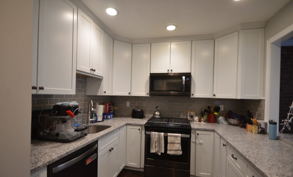 60 Florida Street, Unit 2 Boston, MA 02124 - Photo 11 of 25 a kitchen with stainless steel appliances granite countertop a sink a stove and cabinets