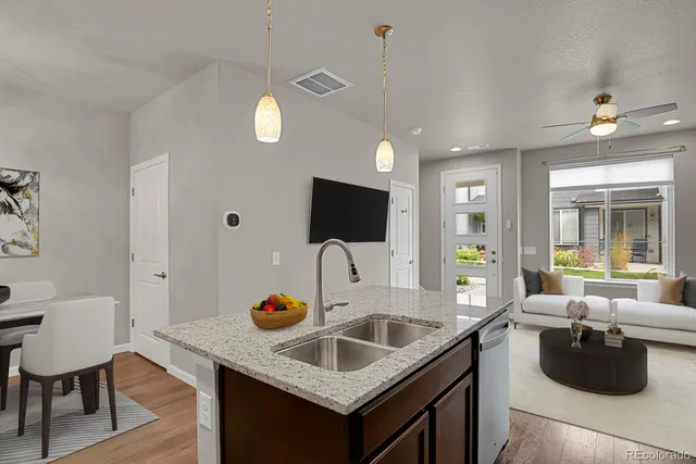 a kitchen with granite countertop a sink and living room