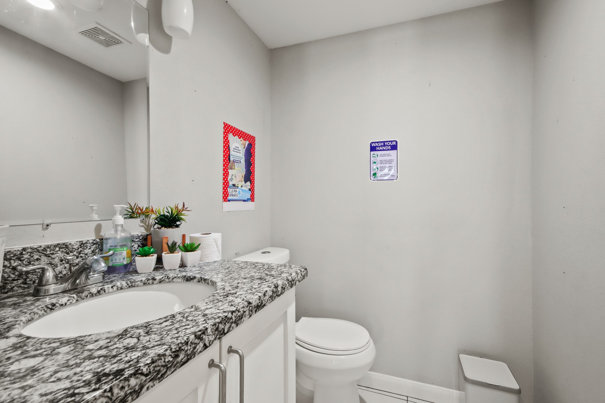 5302 Treaschwig Road Spring, TX 77373 - Photo 28 of 50 a bathroom with a granite countertop sink a toilet and a mirror