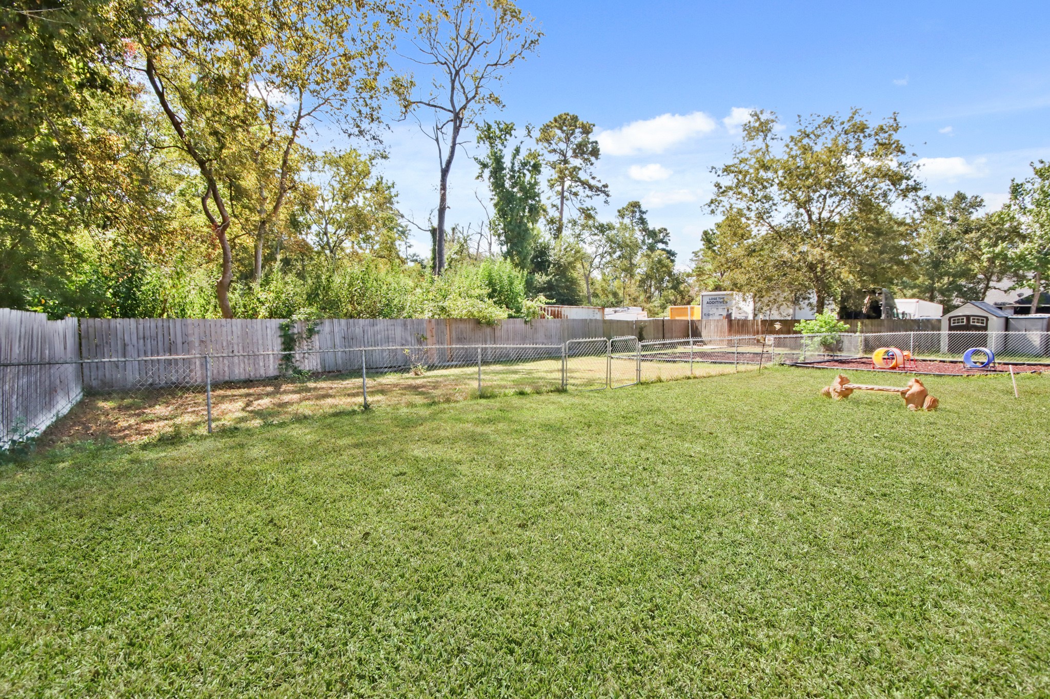 5302 Treaschwig Road Spring, TX 77373 - Photo 8 of 50 a view of a backyard with lawn chairs wooden fence and large trees