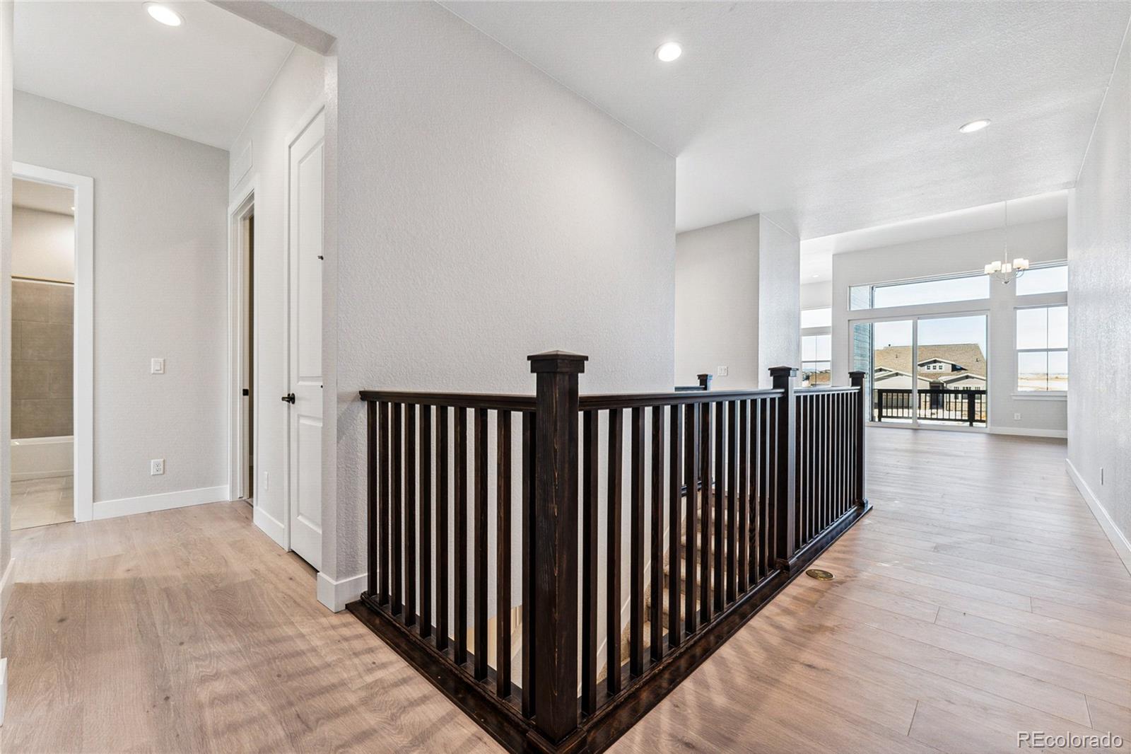 3877 Freestone Point Castle Rock, CO 80108 - Photo 25 of 48 a view of a hallway with wooden floor and windows