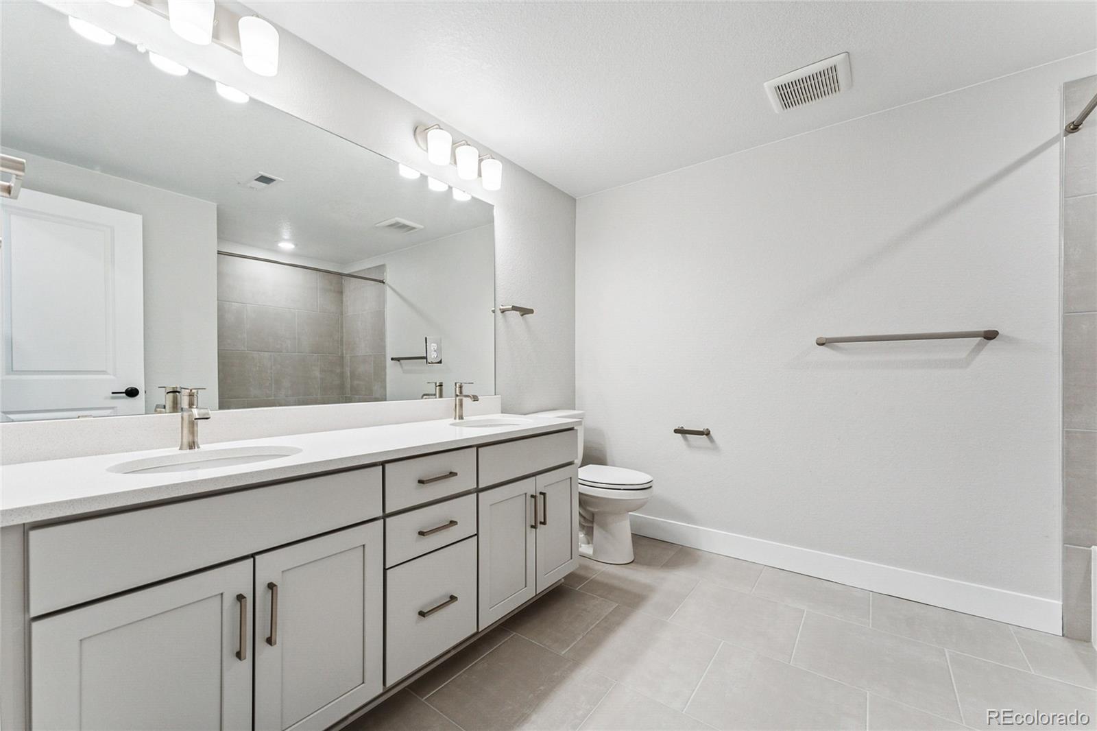 3877 Freestone Point Castle Rock, CO 80108 - Photo 30 of 48 a bathroom with a double vanity sink and mirror