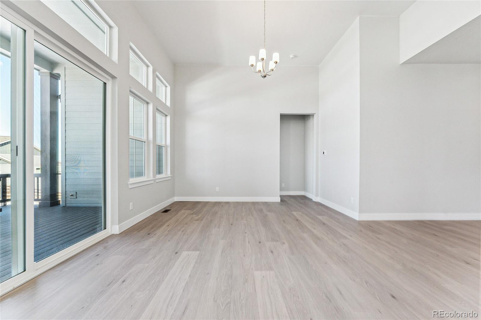 3877 Freestone Point Castle Rock, CO 80108 - Photo 6 of 48 a view of an empty room with wooden floor and a window