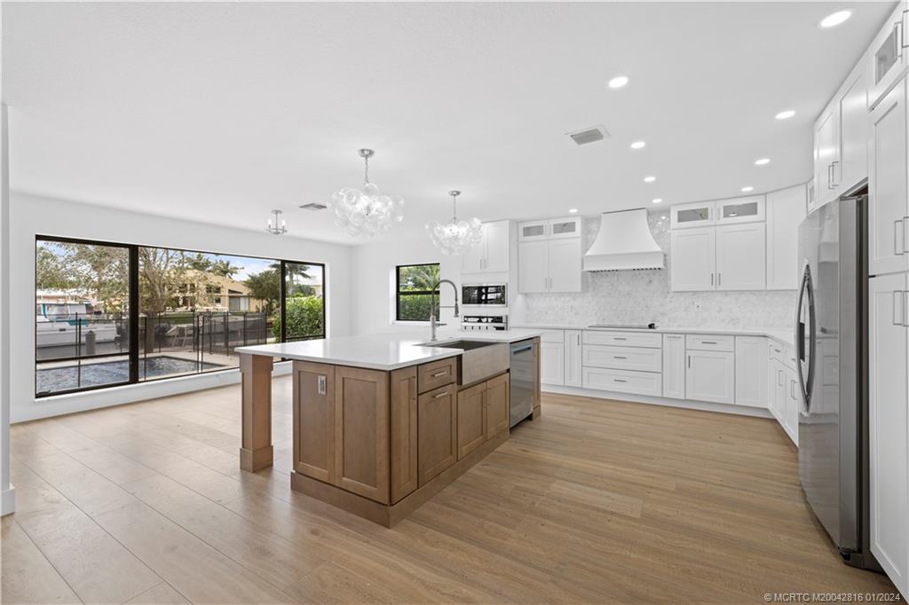 a large kitchen with a large counter top and stainless steel appliances