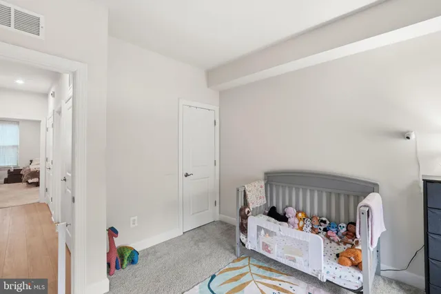 a living room with furniture and baby crib