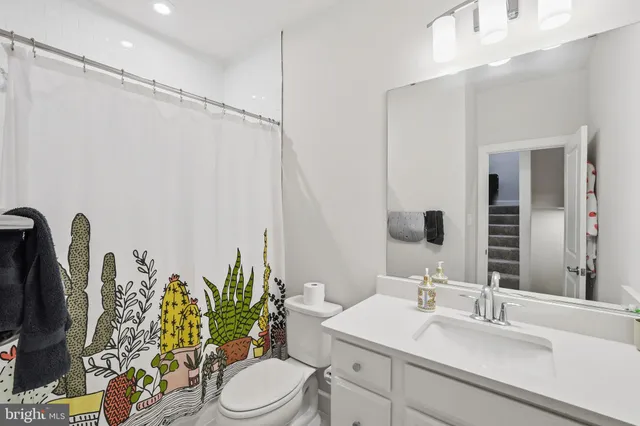 a bathroom with a sink vanity mirror and toilet