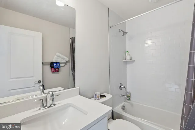 a bathroom with a bathtub shower sink vanity and a toilet