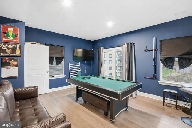a room with furniture pool table and flat screen tv