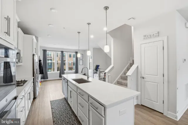 a large white kitchen with a sink a faucet a fireplace and a chandelier
