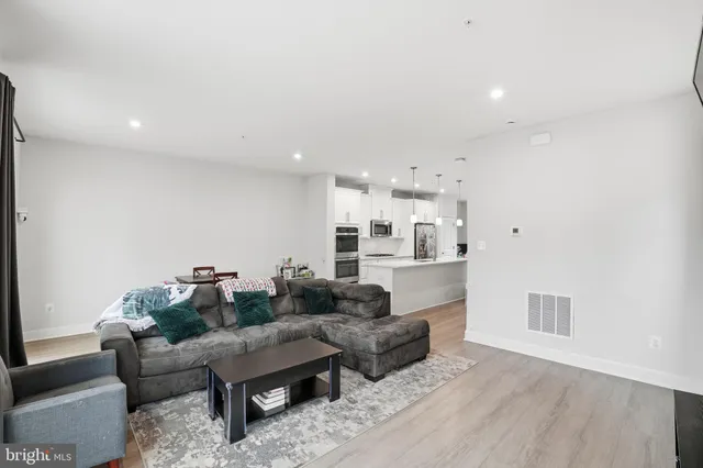 a living room with furniture and a kitchen