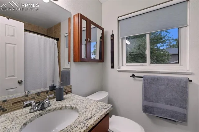 a bathroom with a granite countertop sink and a mirror