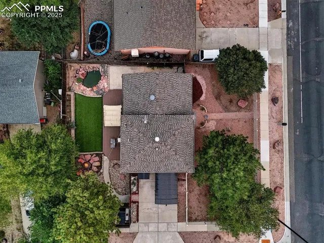 an aerial view of residential houses with outdoor space and trees