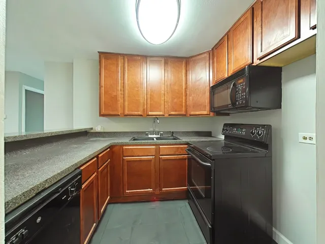 a kitchen with stainless steel appliances granite countertop a sink stove and cabinets
