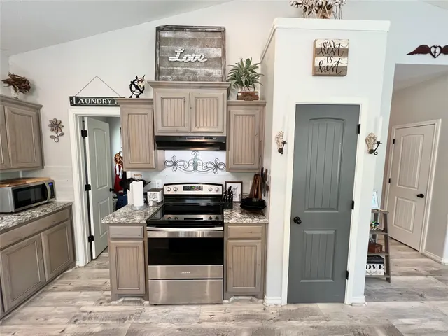 a kitchen with cabinets and steel appliances
