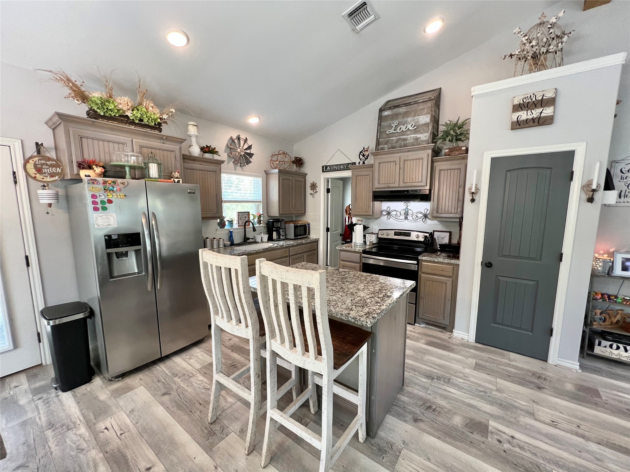 22740 Brazos Circle Damon, TX 77430 - Photo 17 of 30 a kitchen with stainless steel appliances granite countertop a refrigerator a stove a microwave oven a sink with island and chairs
