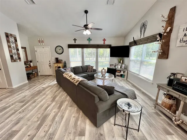 a living room with furniture a flat screen tv and a large window